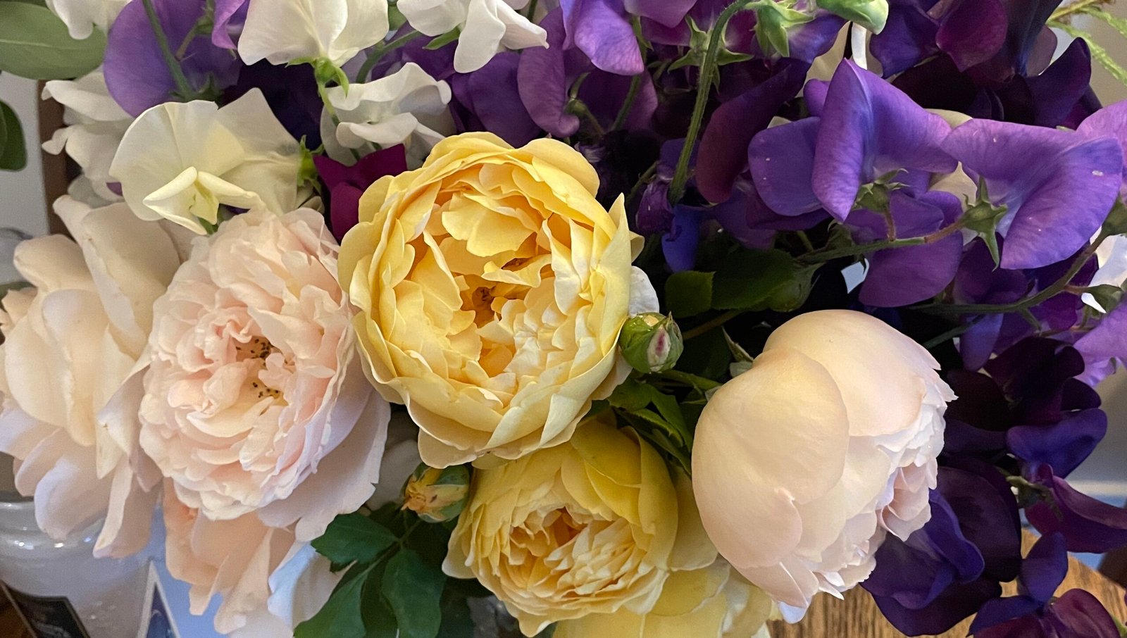 white, cream and yellow roses with purple sweet peas